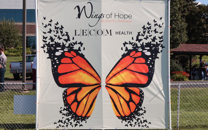 Photo of the Wings of hope butterfly release banner in a field.